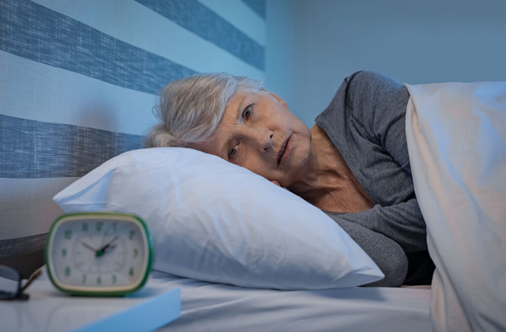 A senior woman lying in bed with her eyes open and unable to fall asleep.