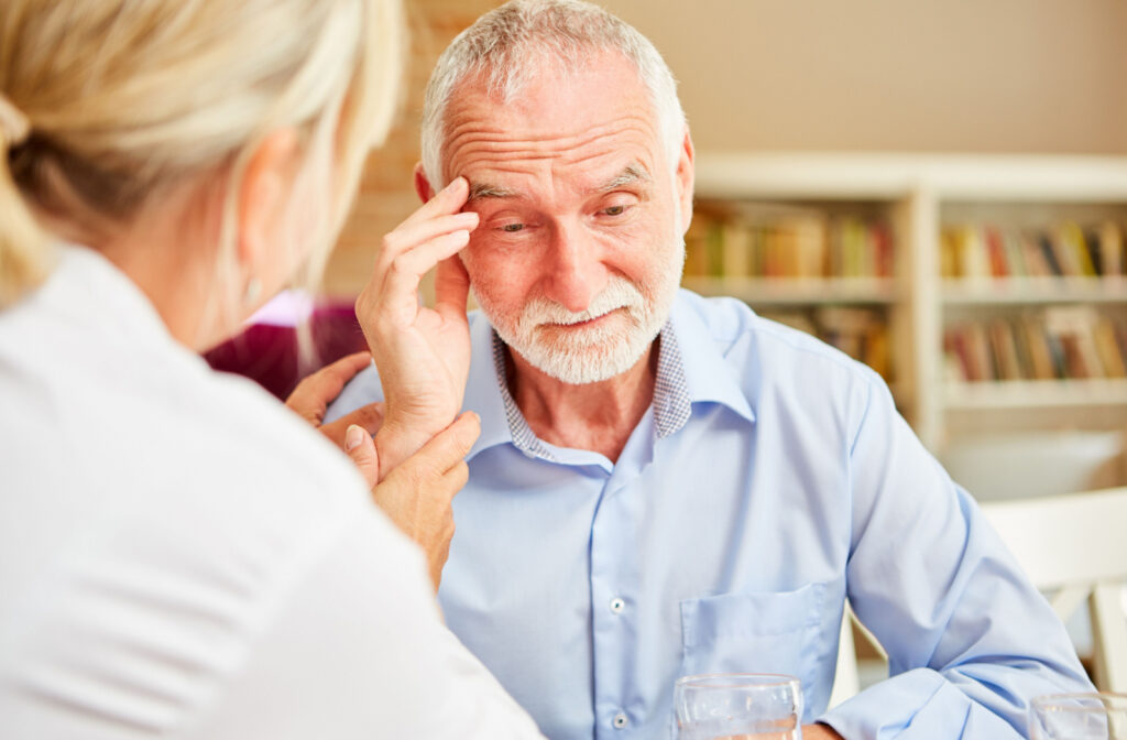 A doctor examining an elderly man who is experiencing disorientation and confusion.
