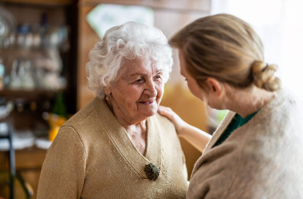 A caregiver talking to a senior woman in a senior living community