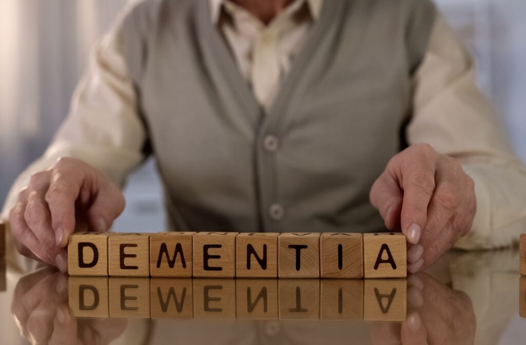 An older adult rearranging word blocks that spell 'dementia.