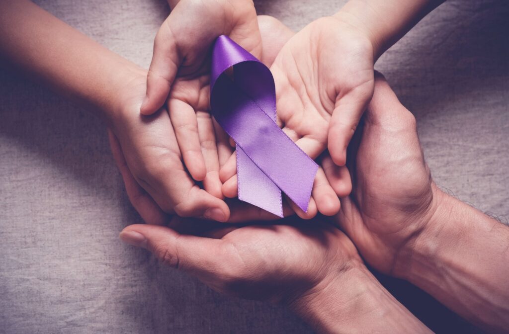 Three family members cradle a purple ribbon, representing Alzheimer’s awareness, to showcase love and support.
