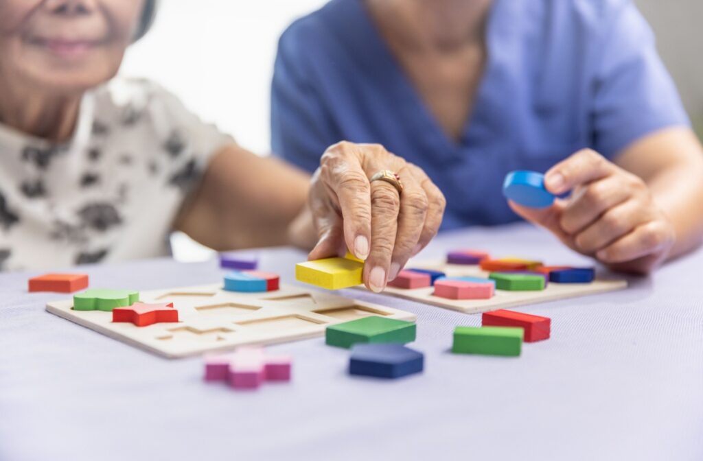 A caregiver and a memory care resident participate in a sensory activity together